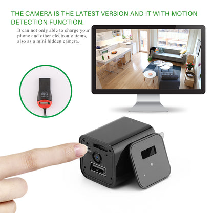 Black mini camera with USB charger, motion detection; monitor shows room view; finger pointing.
