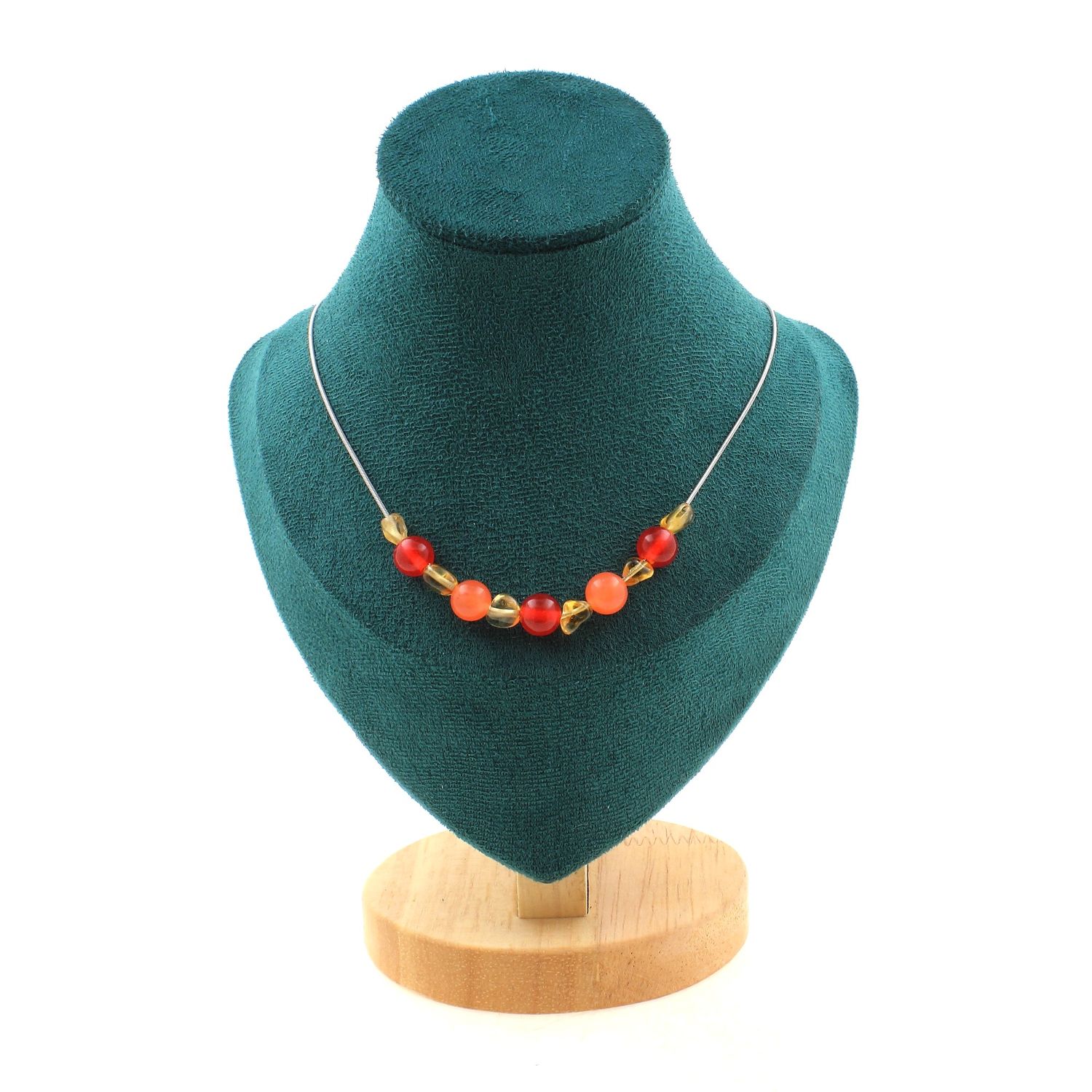 Necklace with red and orange beads on a teal display stand with a wooden base.