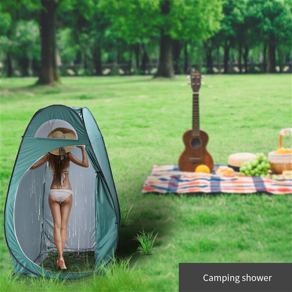 A person under a camping shower tent; picnic setup with guitar on grass.