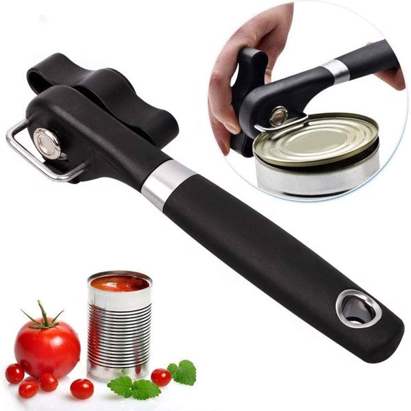 Black can opener with ergonomic handle and circular inset showing can opening; tomatoes nearby.