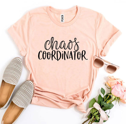 Peach shirt with "Chaos Coordinator" text, beige shoes, sunglasses, and pink roses on a white background.