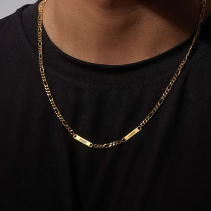 Gold chain necklace with name plates on a person wearing a black shirt.