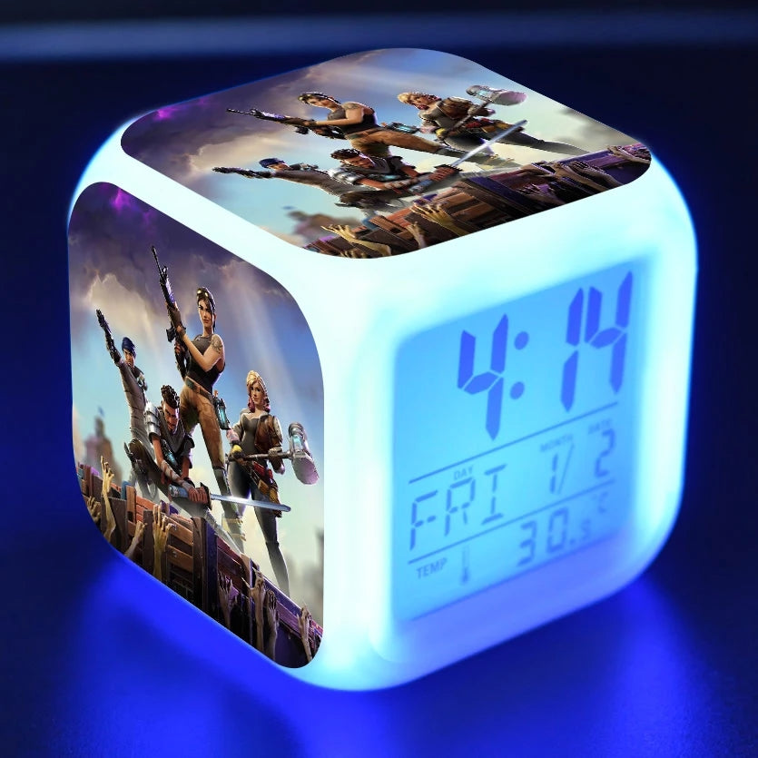 Glowing cube alarm clock with character artwork, showing 4:14, day and temperature.