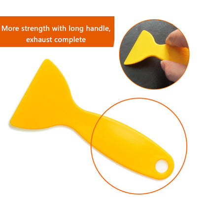 Yellow plastic scraper with long handle, circular grip hole, over white background.