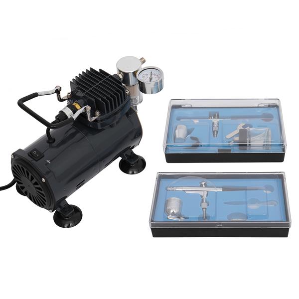 Black air compressor with a pressure gauge, two blue plastic cases containing airbrush tools.