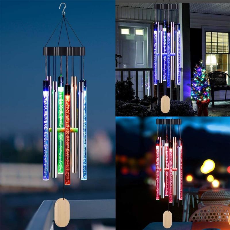 Colorful LED wind chimes with blue, green, and red lights hang outdoors at night.