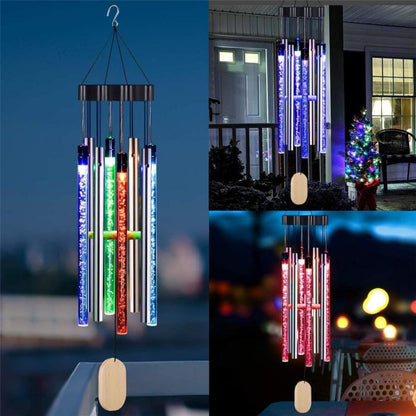 Colorful LED wind chimes with blue, green, and red lights hang outdoors at night.