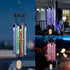 Colorful LED wind chimes with blue, green, and red lights hang outdoors at night.