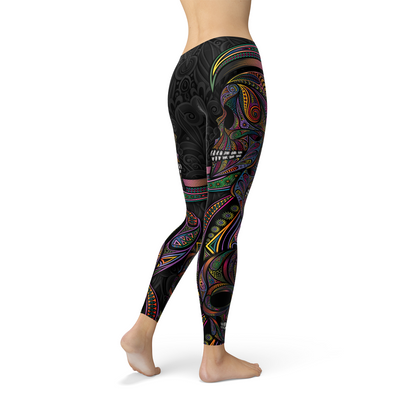 Colorful black leggings with intricate neon rainbow patterns and skull design, worn by a standing person.