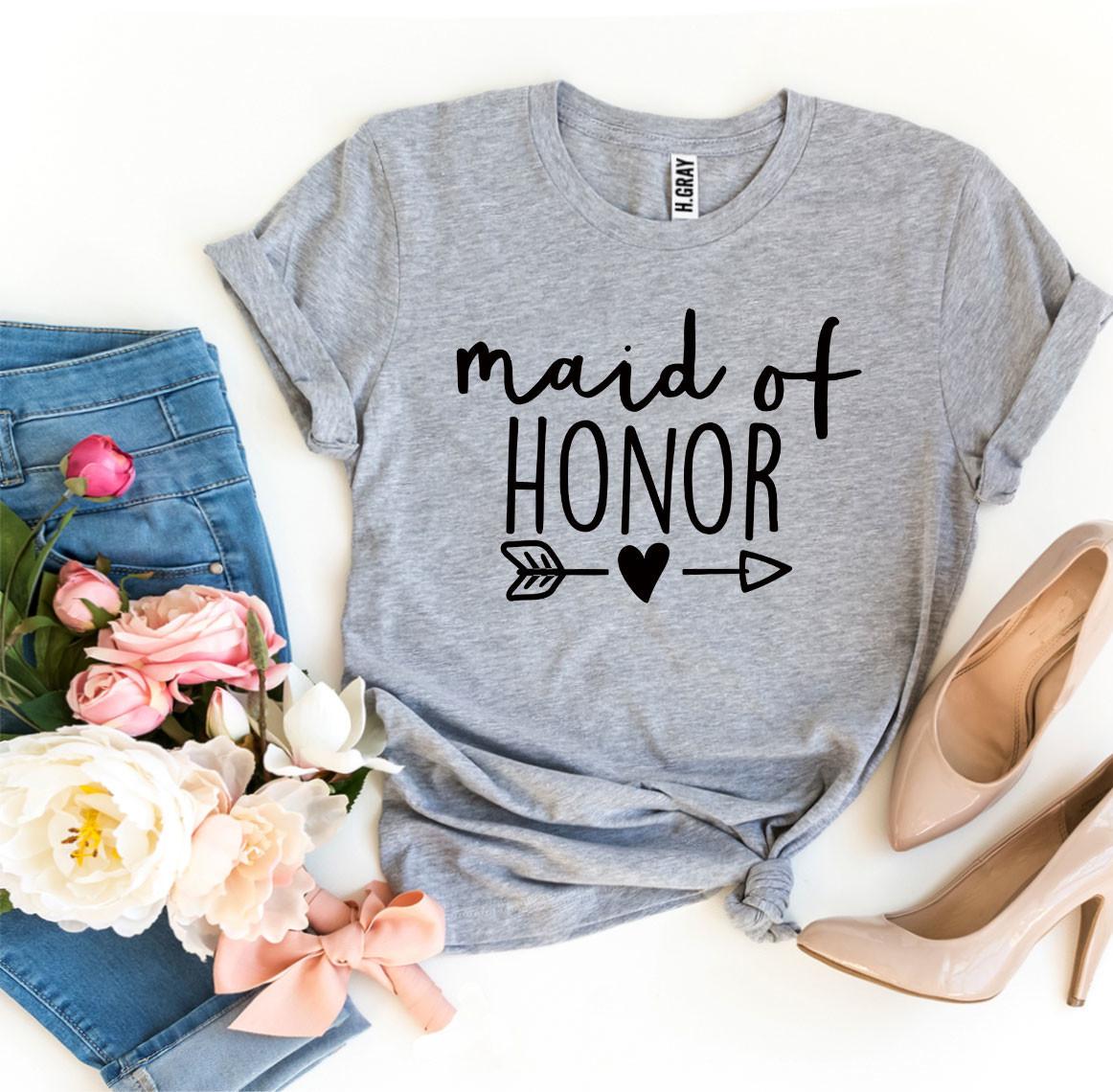 Gray "Maid of Honor" T-shirt with flowers, blue jeans, and nude heels arranged on white background.