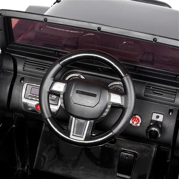 Black toy car dashboard with a steering wheel, buttons, dials, and a tinted windshield.