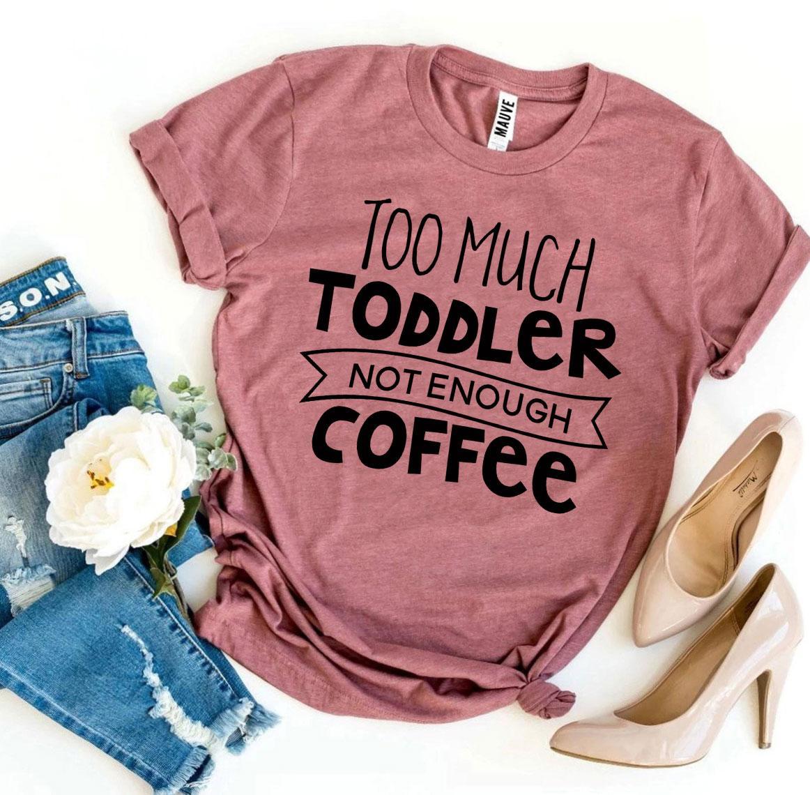 Pink T-shirt with “Too much toddler, not enough coffee” text, paired with ripped jeans and beige heels.