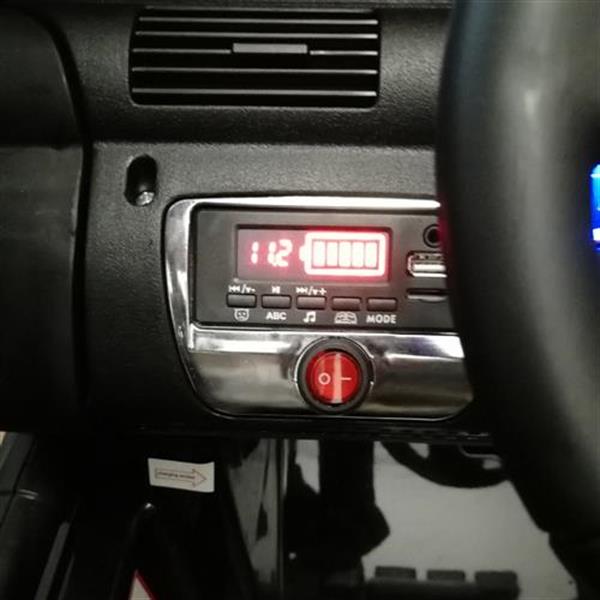 Car dashboard with a digital display showing "112," buttons, and a red power button in the center.