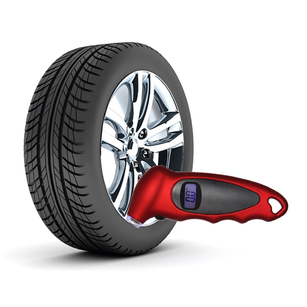 Black tire with shiny silver rim next to a red digital tire pressure gauge on white background.