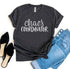 Dark gray T-shirt with "Chaos Coordinator" text, paired with blue jeans and black shoes.
