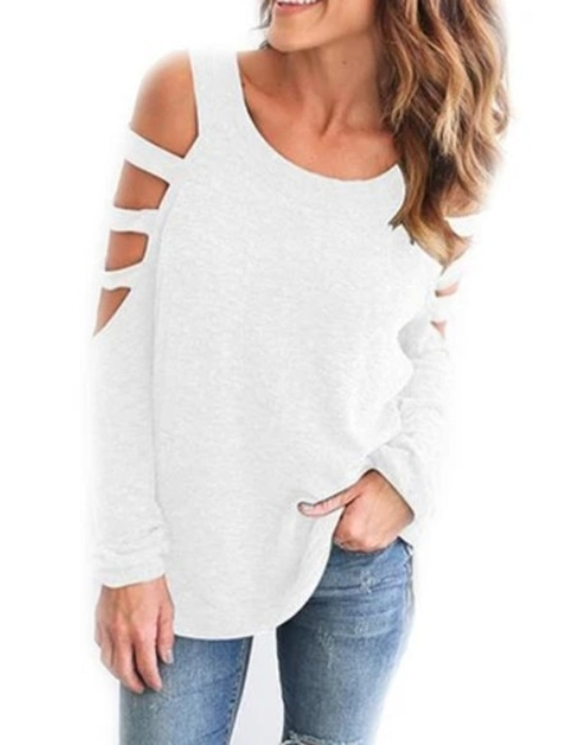 Woman wearing a white, cold-shoulder top with cut-out sleeves, and blue jeans; brown wavy hair.