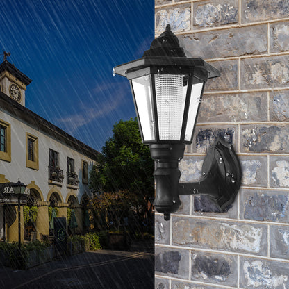 Black wall lantern on wet brick wall with rain, building and tree in the background under blue sky.