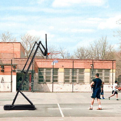 Outdoor basketball court with a bent hoop, red brick building, and people playing under a blue sky.