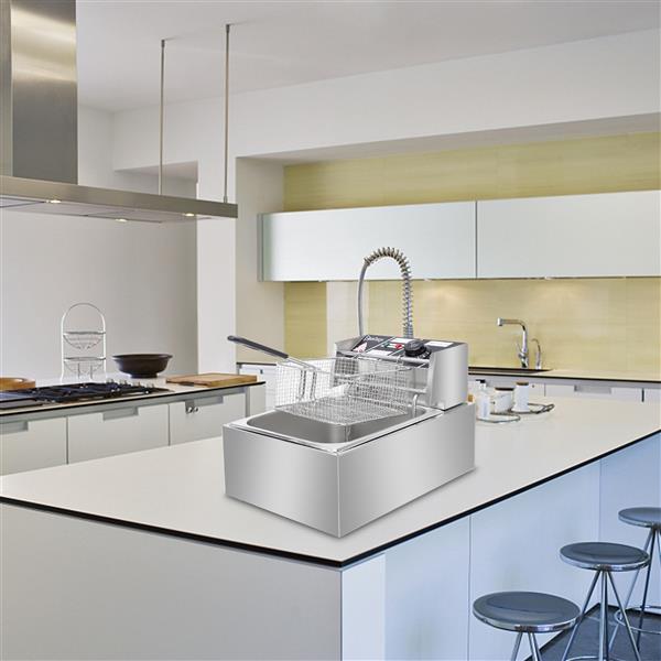 A sleek, silver deep fryer on a modern white kitchen island with stools and minimalistic decor.