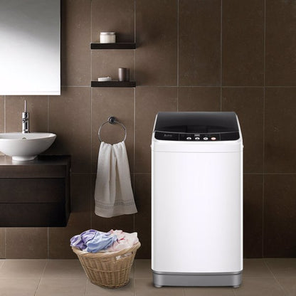 Washing machine in a modern bathroom with brown tiles, a laundry basket, and a wall-mounted sink.