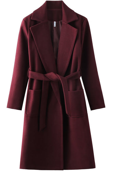 Long burgundy coat with a belt, wide lapels, and large front pockets.
