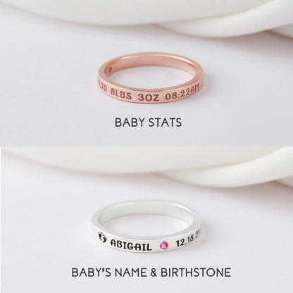 Rose gold ring with stats engraving, silver ring with name, pink gem, and footprints design.