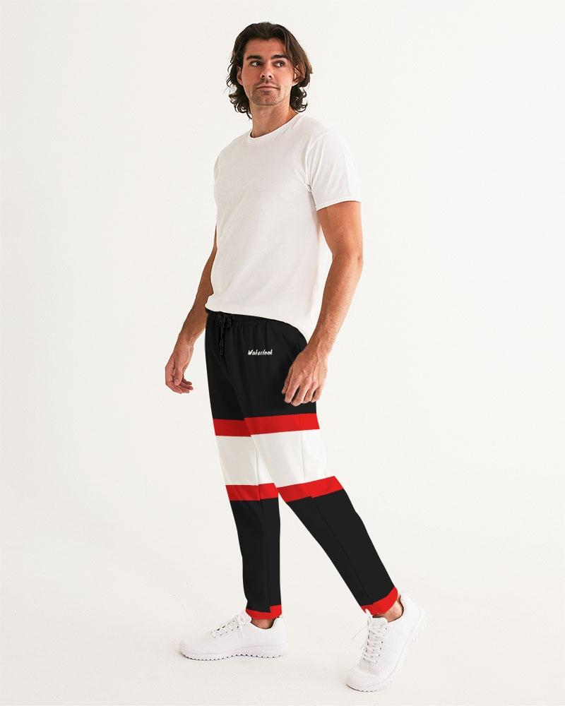 Man in a white t-shirt with black pants featuring red and white stripes, and white sneakers.