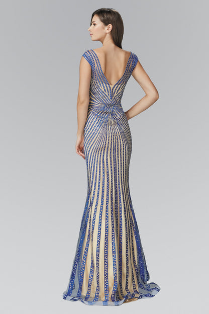 Woman in a blue and beige patterned gown with a deep V-back, standing sideways on a gray background.