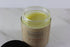 Open jar of yellow hair and nail mask on a marble surface, labeled "Butter Me Up Organics".