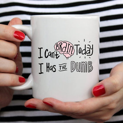 Hands with red nails hold a white mug with "I can&