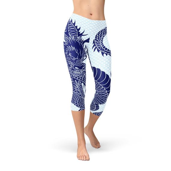 Woman wearing white leggings with a large blue dragon print, standing barefoot.
