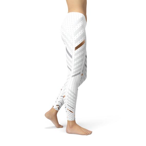 Side view of a person wearing white leggings with diagonal stripes and polka dots, barefoot.