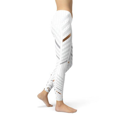 Side view of a person wearing white leggings with diagonal stripes and polka dots, barefoot.