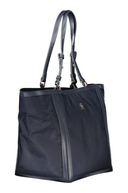 Dark blue tote bag with leather straps and gold logo detailing on the side.