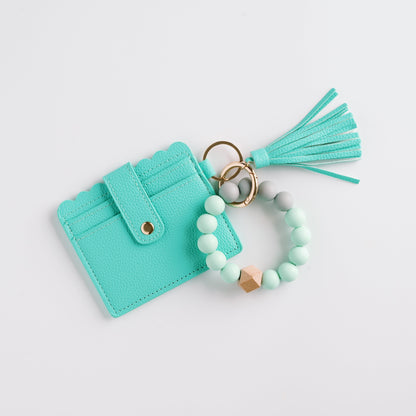 Turquoise cardholder with scalloped edge, beaded keychain, and matching tassel on white background.